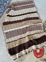 Full view of crocheted striped afghan laid flat
