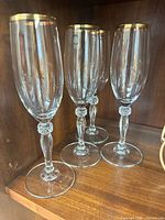 Four Cortina pattern champagne flutes on shelf