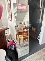 Full view of frameless mirror leaning against wall