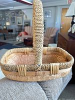 Side view of rectangular wicker basket showing weave, rim, and handle