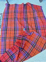 Full view of plaid lap blanket laid flat showing pattern and colors