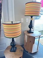 Both lamps on display tables showing bases and striped shades