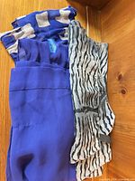 Stack of three distinct scarves showing colors and patterns