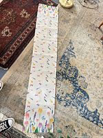 Full length view of white floral table runner on rug