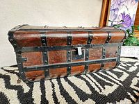 Full view of wooden trunk front with iron straps and lock plate
