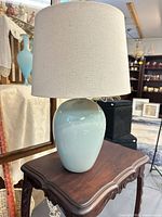 Full view of soft blue ceramic table lamp with linen shade