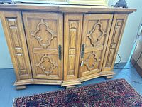 Front view showing ornate doors, hardware, feet