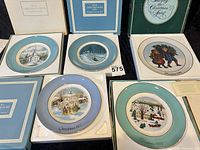 All five Avon Christmas plates laid out with boxes visible
