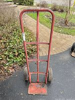 Front view of red steel hand dolly showing full frame and wheels