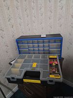 Blue multi-drawer cabinet with open Stanley SortMaster case displaying compartments