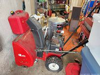 Left side view showing full snow blower, fuel can visible