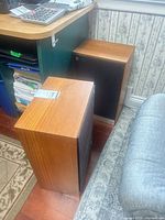 Two wood-veneer Mordaunt Pajeant Series speakers beside desk
