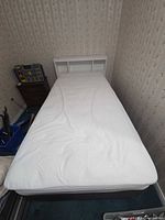 Overhead view of assembled single bed showing headboard shelves, mattress surface, frame partially visible