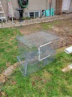 Overall view of galvanized wire live animal trap on lawn