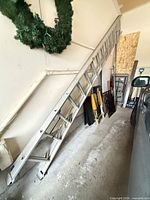 Full view of aluminum extension ladder leaning against wall
