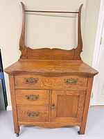 Front view showing entire washstand with backsplash, drawers, cabinet door, brass hardware