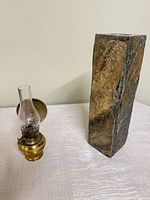 Brass lamp beside tall stone candle holder