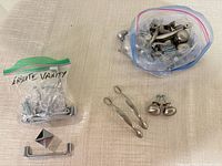 Two zipper bags and loose hardware showing knobs, pulls, screws