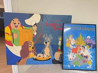 Both artworks standing against wall: painting and framed poster