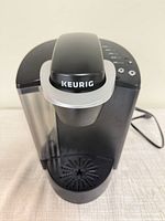 Front top view showing overall appliance, Keurig logo, water reservoir and drip tray