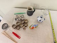 All items laid out: napkin rings, pitcher, glass vase, bud vase, ladle, chopsticks, napkin holder