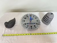 Overview of clock, bird box closed, and stacked stone holder with tape for scale