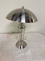 Front view of brushed nickel dome table lamp standing on surface