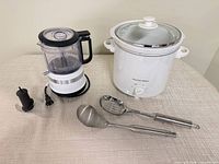Slow cooker, food processor, ladle, slotted spoon front view