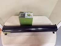 Pump box and black sewer hose storage tube on table