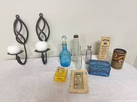 All items overview on table including sconces with candles, bottles, tins, boxes