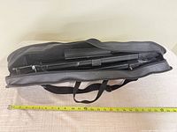 easel collapsed inside open carrying case with measuring tape showing length