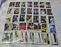 Spread of Battlestar Galactica trading cards arranged in rows with additional stack