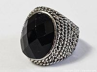 Front view of ring showing oval faceted black stone and bezel