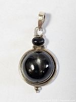 Front view showing overall design, two onyx cabochons and silver setting
