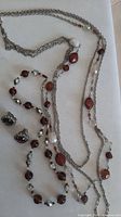 Overview showing two necklaces and pair of earrings