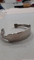 Angled view of silver-tone cuff bracelet