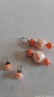 Both pairs of coral earrings laid flat