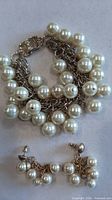 Bracelet and earrings laid flat showing pearl clusters and clasp