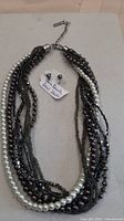 Full view of necklace and earrings showing multi-strand design and matching studs