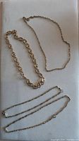 All four gold-tone link necklaces arranged together