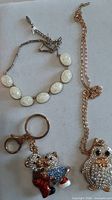 Group shot showing Lucite necklace, teddy bear keychain and penguin necklace