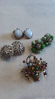 Group shot: brooch and three pairs earrings