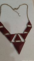 Full view of necklace showing triangular red panels and chain
