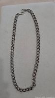 Full view of silver-tone chain laid flat showing length and link style