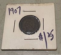 Obverse of 1907 Indian Head cent in holder marked "1907" and "$25"