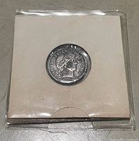 Coin in holder, obverse visible