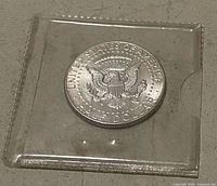 Reverse of 1964 Kennedy half dollar in vinyl sleeve