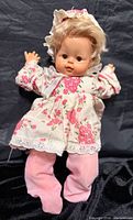 Front view of doll in floral dress and pink pants