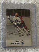 Card front showing Frank Mahovlich skating in Maple Leafs uniform with printed signature