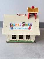 Front view showing Fisher-Price Play Family School logo on roof